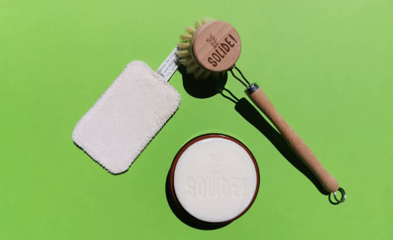 Le savon et son récipient accompagné d'une éponge et d'une brosse pour laver sa lessive écologiquement